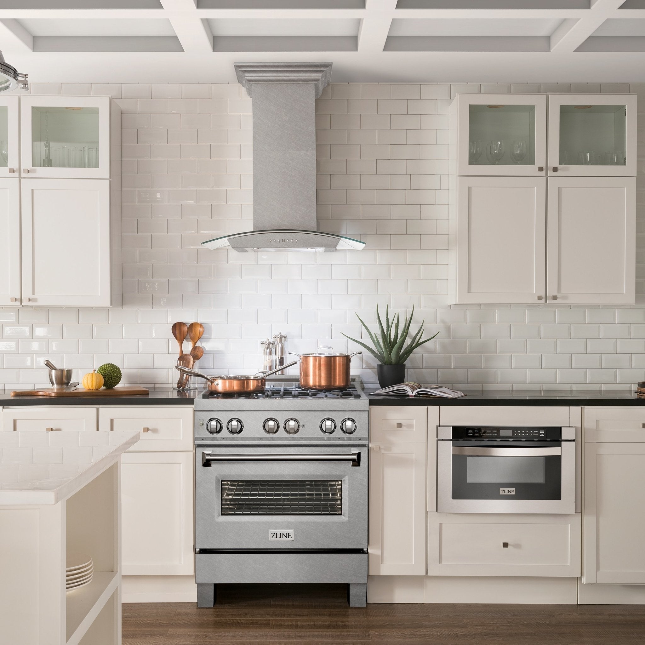 ZLINE Ducted Wall Mount Range Hood in Fingerprint Resistant DuraSnow Stainless Steel & Glass (8KN4S) in a cottage-style kitchen with white cabinets and walls.